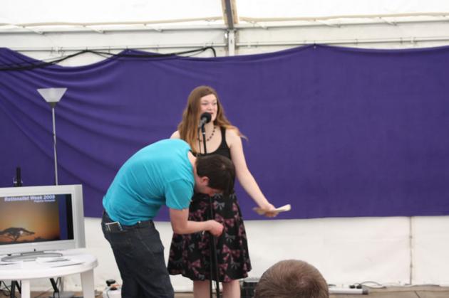 Rich adjusts Nicola's microphone.