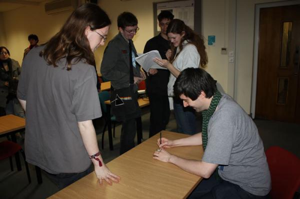 Rich signs autographs for his fans.
